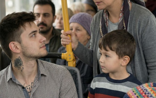 Otobüste, yanında iki çocuğu olan bir kadın ayakta bekliyordu